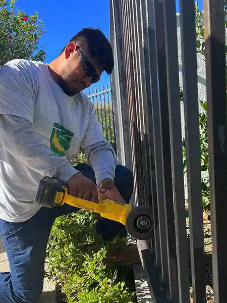 Crew worker grinding metal fence